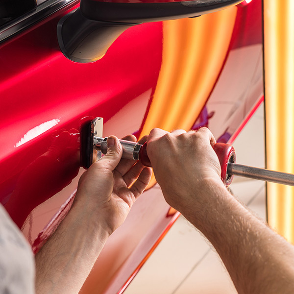 technician removes dents on the car