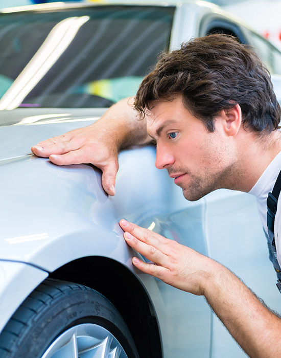 mechanic examine car finish on dents