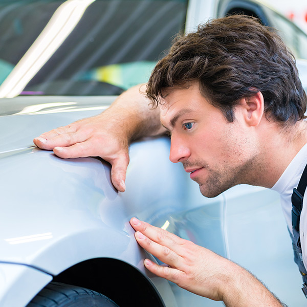 mechanic examine car finish on dents